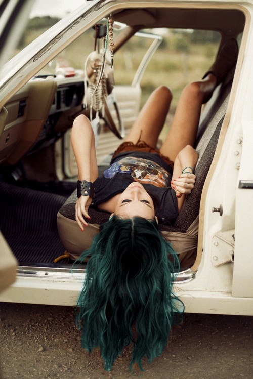 девушка с зелеными волосами лежит на сиденьях автомобиля висит ловец снов с перьями