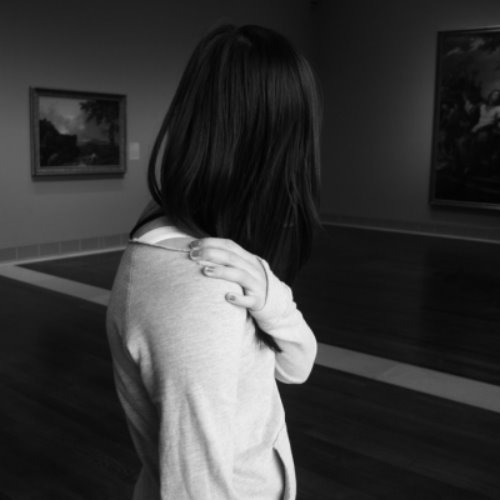 девушка с средними волосами рассматривает картины