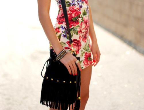 девушка в платье с цветочным принтом и черной сумочкой с бахромой