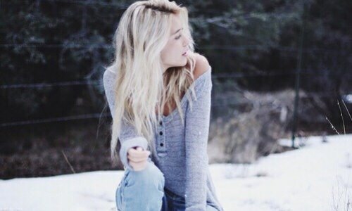 блондинка присела на снегу с оголенным плечом