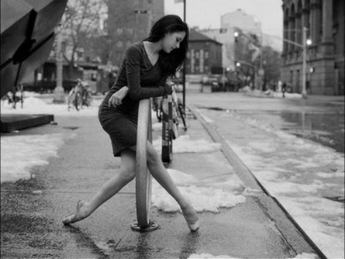 балерина танцует среди обледеневшей улицы в платье