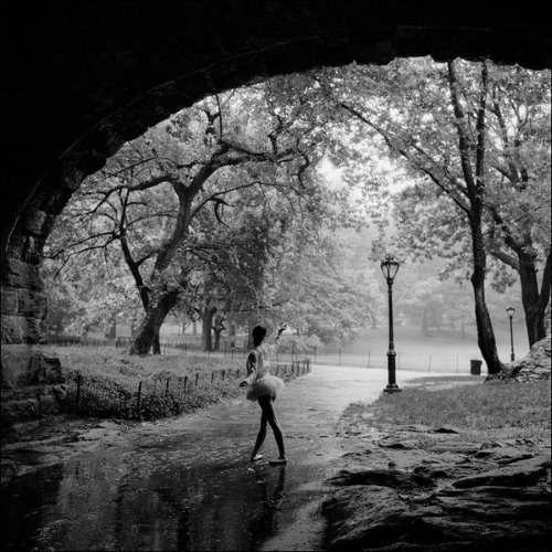 балерина в юбочке в парке под мостом мокрый асфальт