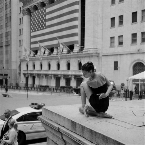 красивая балерина со спины присела на фоне американского флага