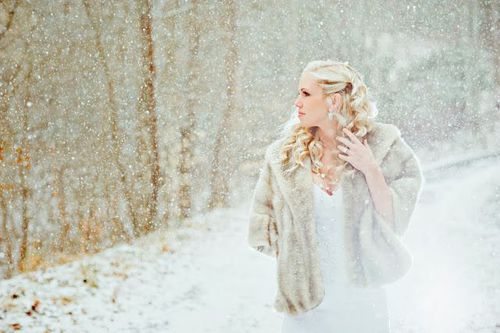 очень красивая девушка блондинка в белом платье и меховой накидке в снегопад