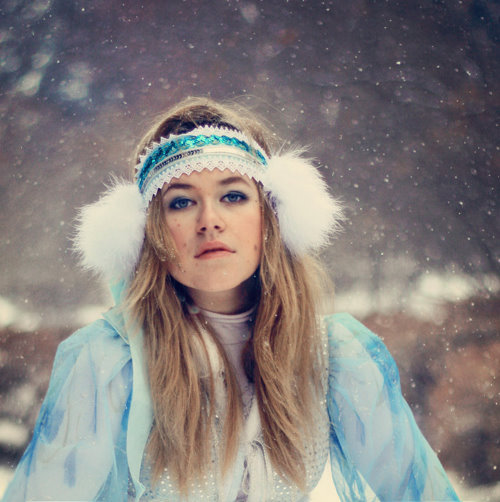 девушка со светлыми волосами зимой под снегом в голубом новогоднем костюме