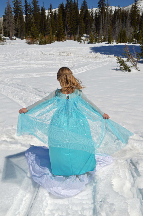 фото девочки спиной бегущей по снежной тропинке в сторону леса в голубом красивом платье Снегурочки