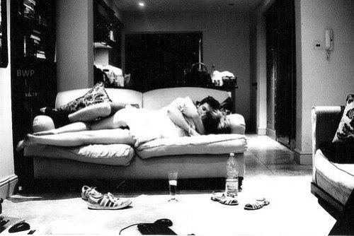 черно белое фото пары которая страстно обнимается на диване, возле него обувь, бутылка и бокал