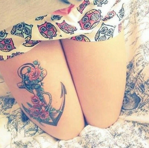 Домашняя одежда с милым принтом с совами. На правом бедре татуировка в виде якоря с веревкой и розами. Девушка на коленях.