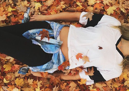 повязанная на бедрах синяя рубашка, девушка лежит в листьях