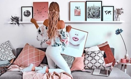 Девушка украшает свою комнату картинами со спины не видно лица