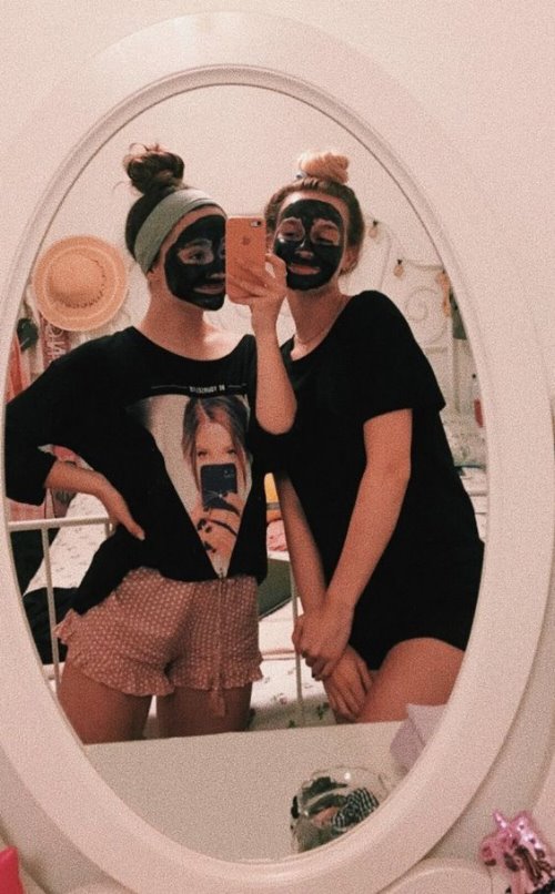 Две озорные подружки перед зеркалом в черных масках