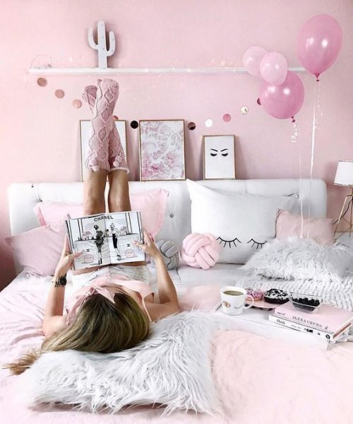 Девушка вверх ногами в розовых вязаных носочках читает журнал