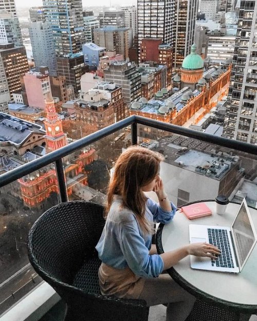 Девушка учится дома на балконе по удаленке на ноутбуке