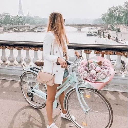 Девушка в пиджаке катается на велосипеде по мостам без лица