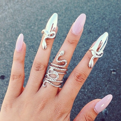 Кольца в виде змей и ногтевых пластин на руке у девушки с розовыми ногтями