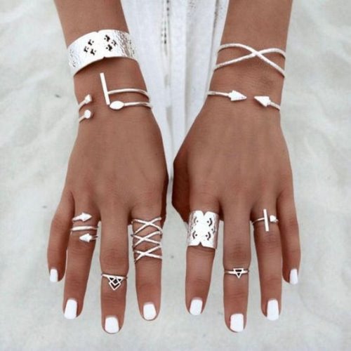 Фаланговые кольца и браслеты на смуглой коже девушки в белом платье