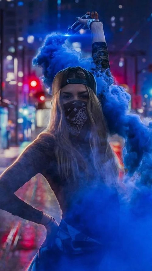 Девушка в маске пускает дым