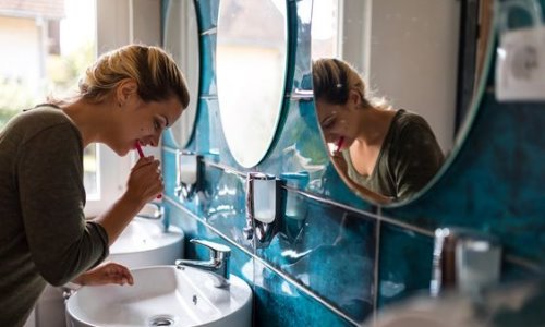 Девушка в общежитии чистит зубы и умывается