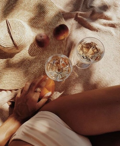Девушка на пляже с персиками и напитками