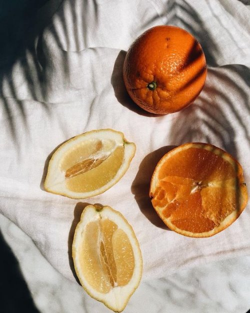 Половинки лимона и апельсина в тени