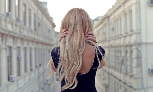 блондинка в черном платье со спины с красными ногтями
