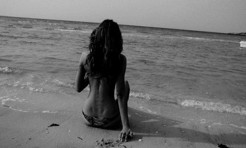 черно-белое фото девушка спиной сидит на пляже моря