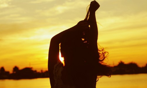 силуэт девушки возле водоема в лучах солнца волосы на ветру