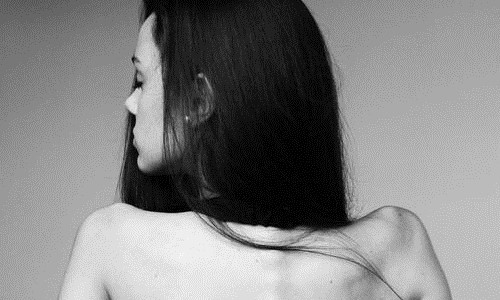 чернобелое фото девушки спиной сквозь волосы просвечивает ухо