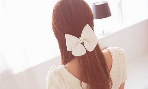 девушка спиной с бантом в волосах в белой комнате нежное фото